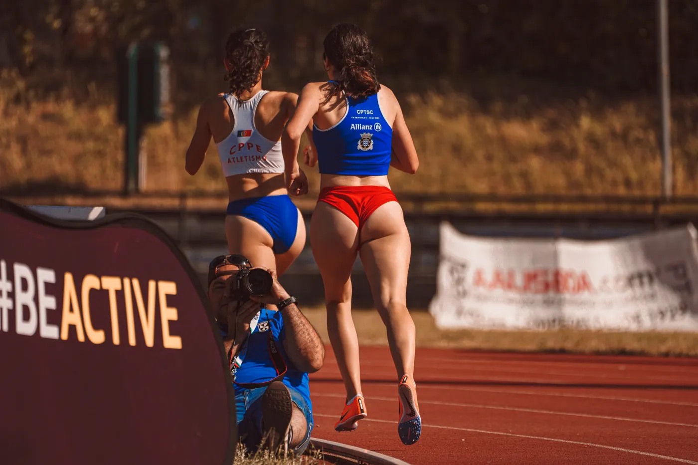 Two runners training on an athletics track