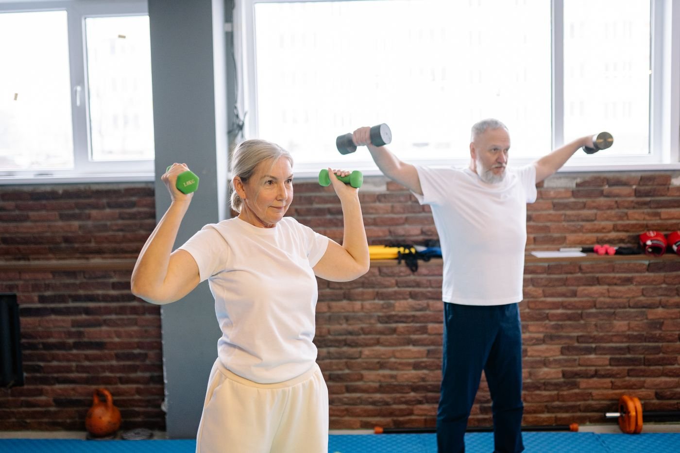 Older man and woman lifting dumbbells for strength and functional fitness