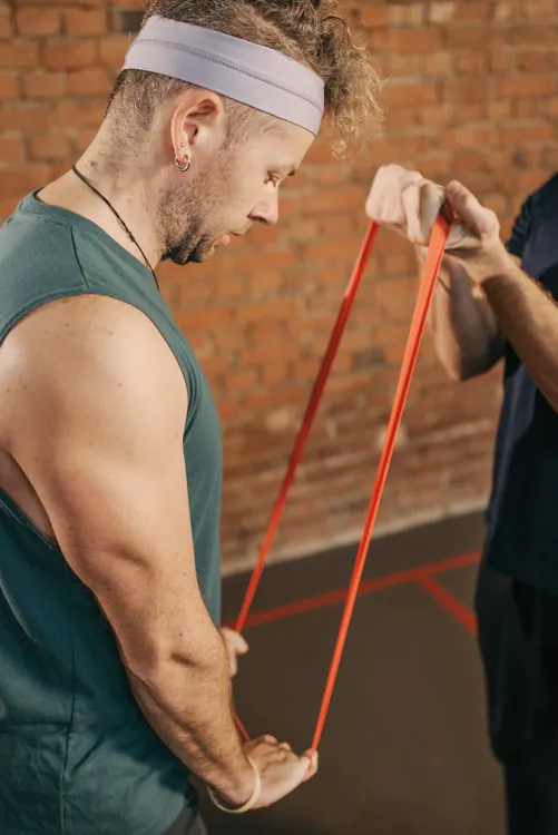 Man working against a resistance band in a gym training session
