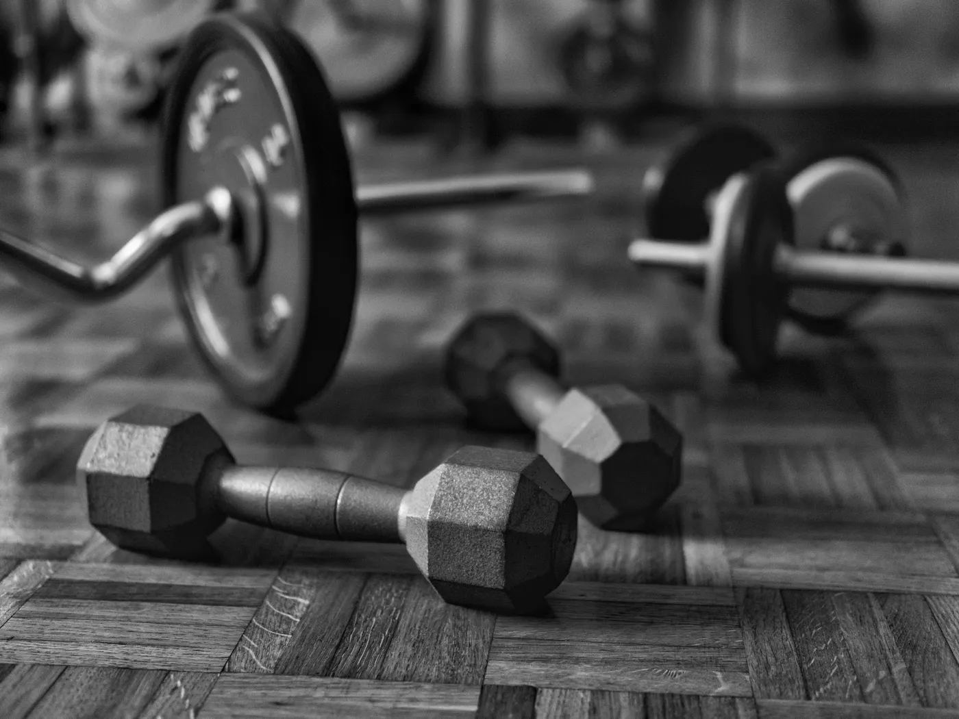 Dumbbells and barbells on a wooden gym floor