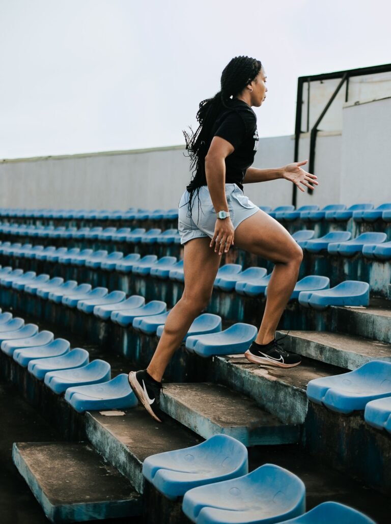 Woman climbing blue stadium steps during a short, vigorous stair workout