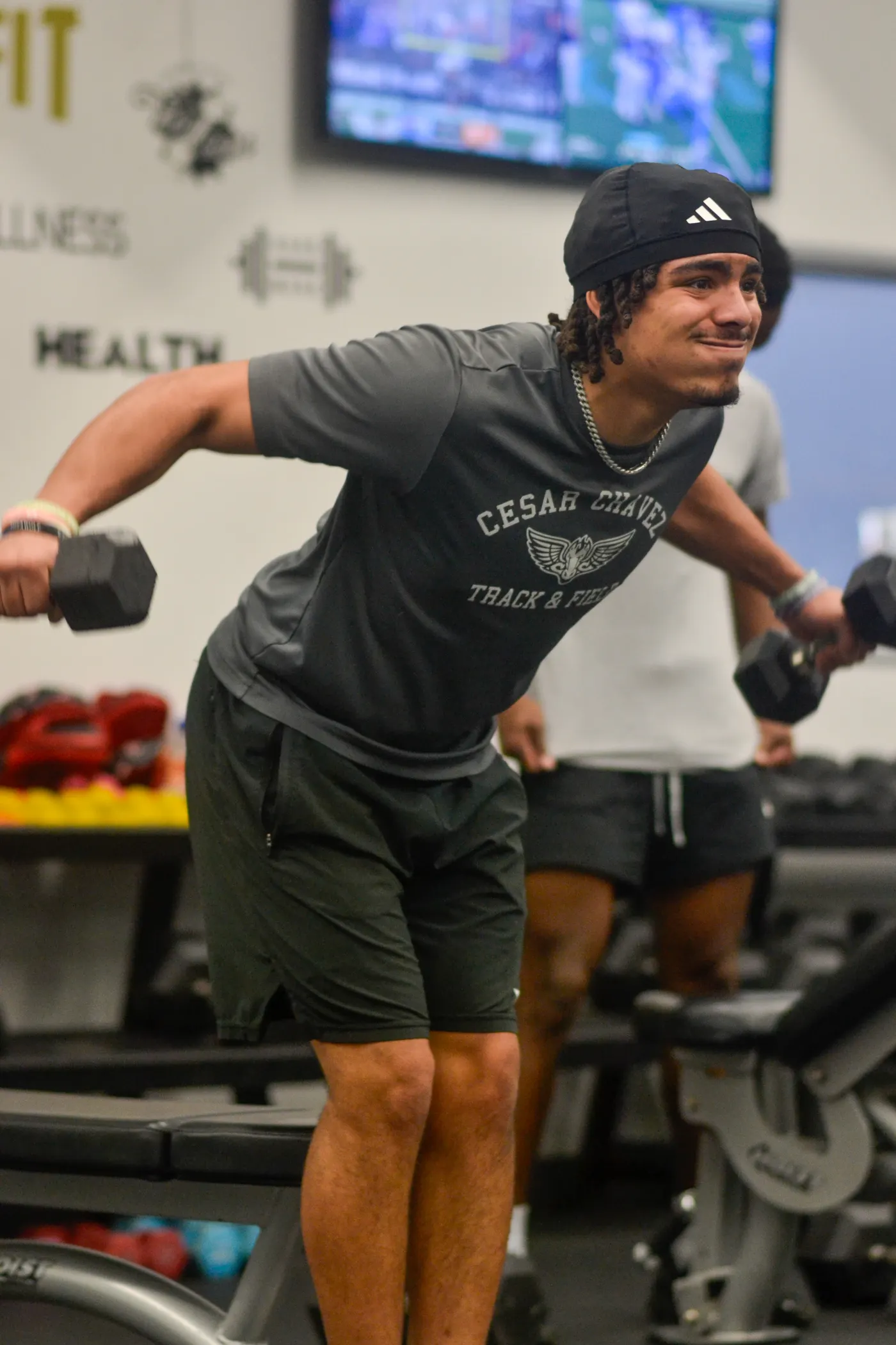 Young man lifting dumbbells during a gym strength session