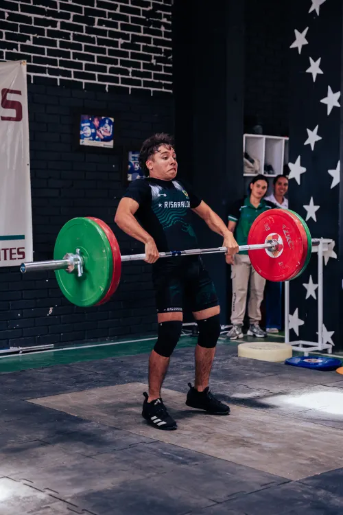 Young athlete performing a barbell lift in a gym