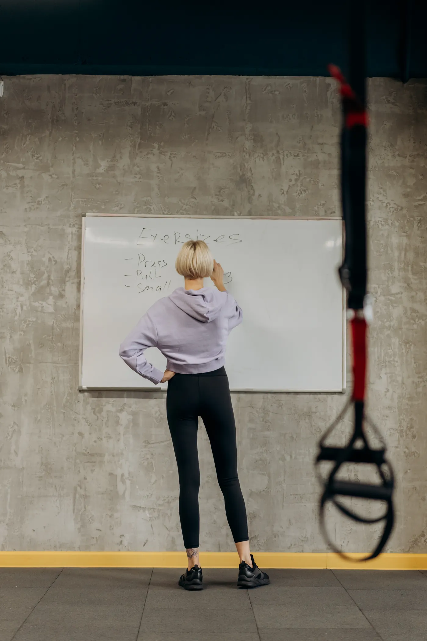 Fitness instructor planning a workout on a whiteboard