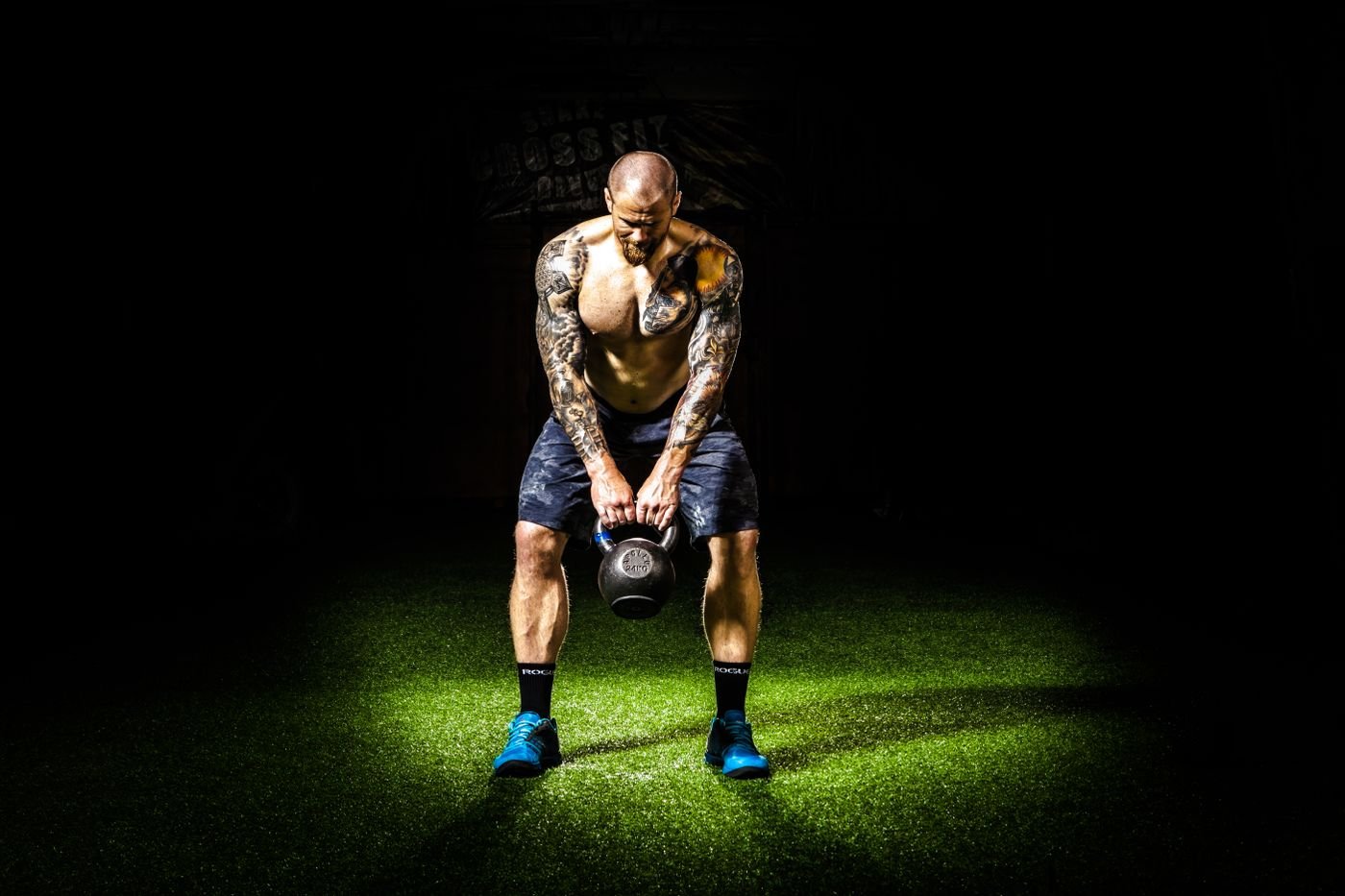 Athlete lifting a kettlebell in a dark gym