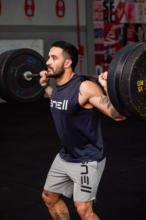 Man performing a heavy barbell squat in a gym