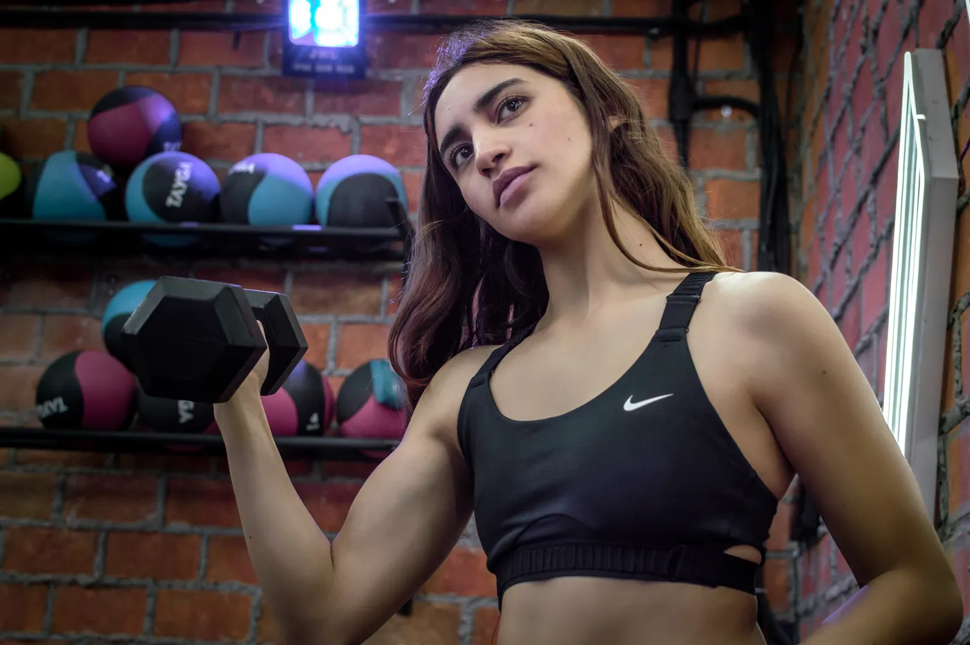 Woman training with a dumbbell during a controlled gym session