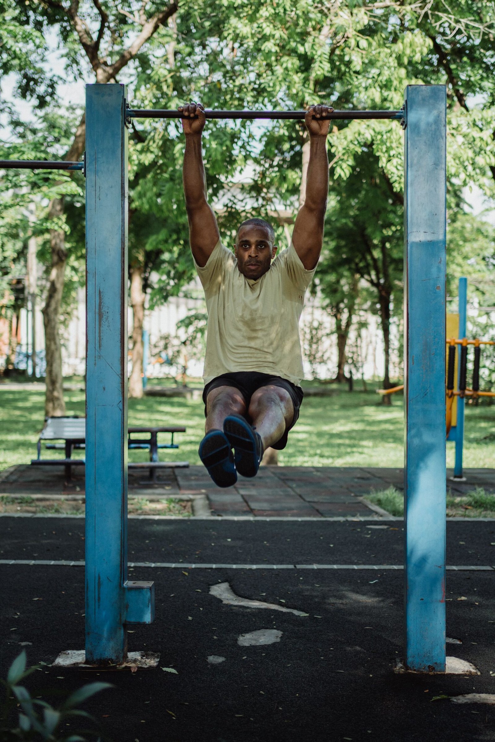Man performing pull-ups on an outdoor bar