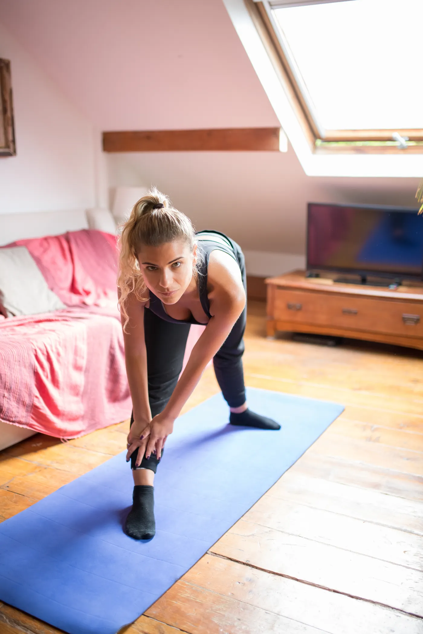 Woman stretching her legs on an exercise mat