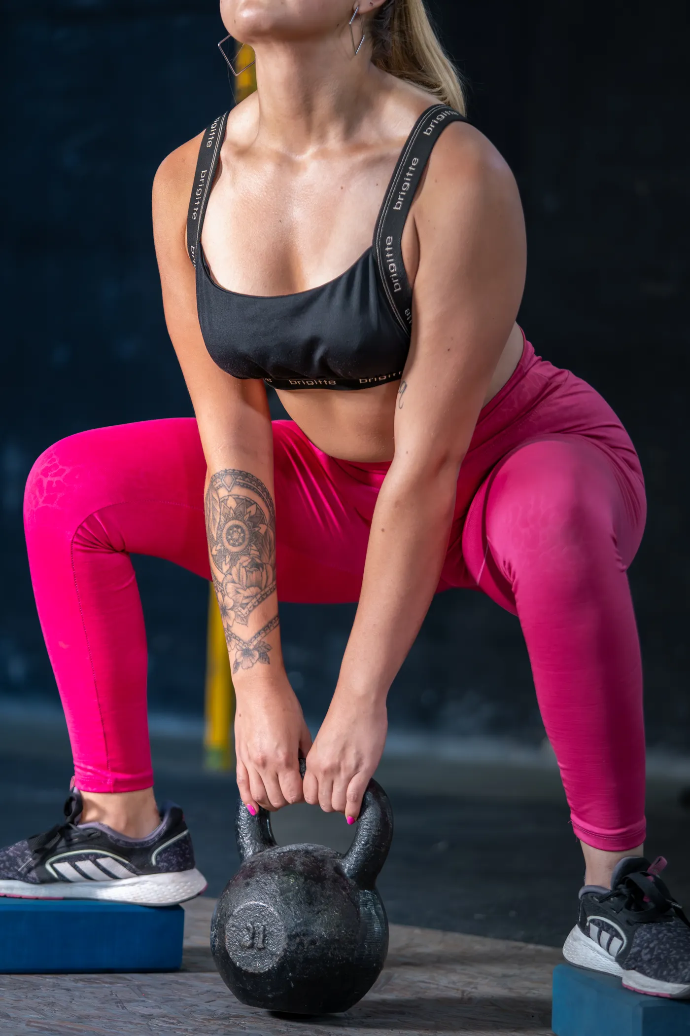 Woman performing a kettlebell squat in a gym