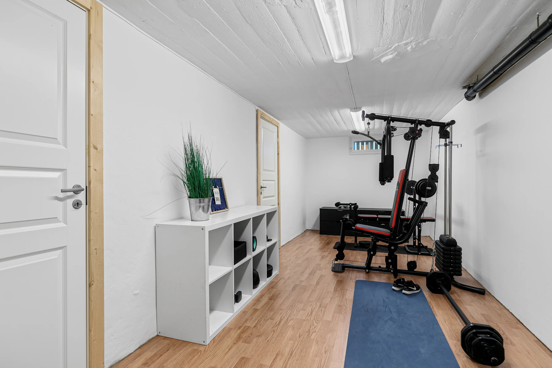 Home exercise space with a blue mat and compact equipment