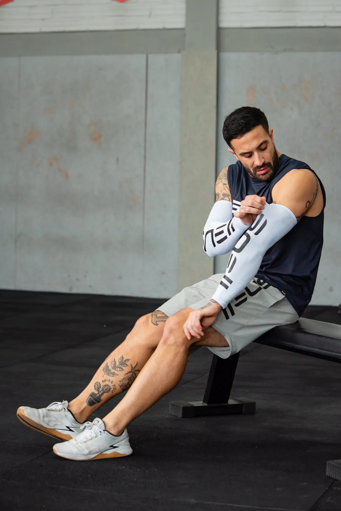 Muscular athlete resting on a bench between gym sets
