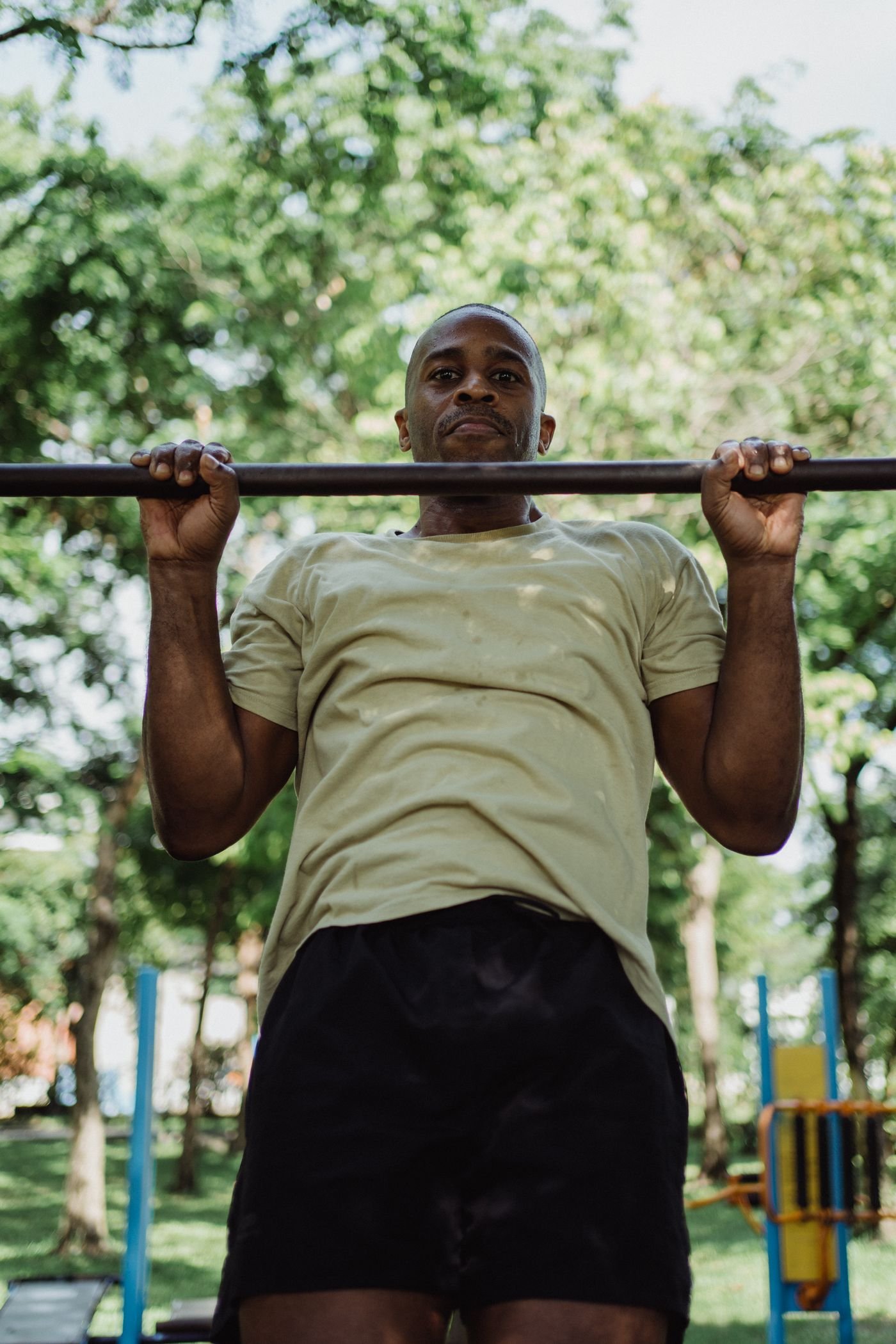 Athlete hanging from an outdoor pull-up bar