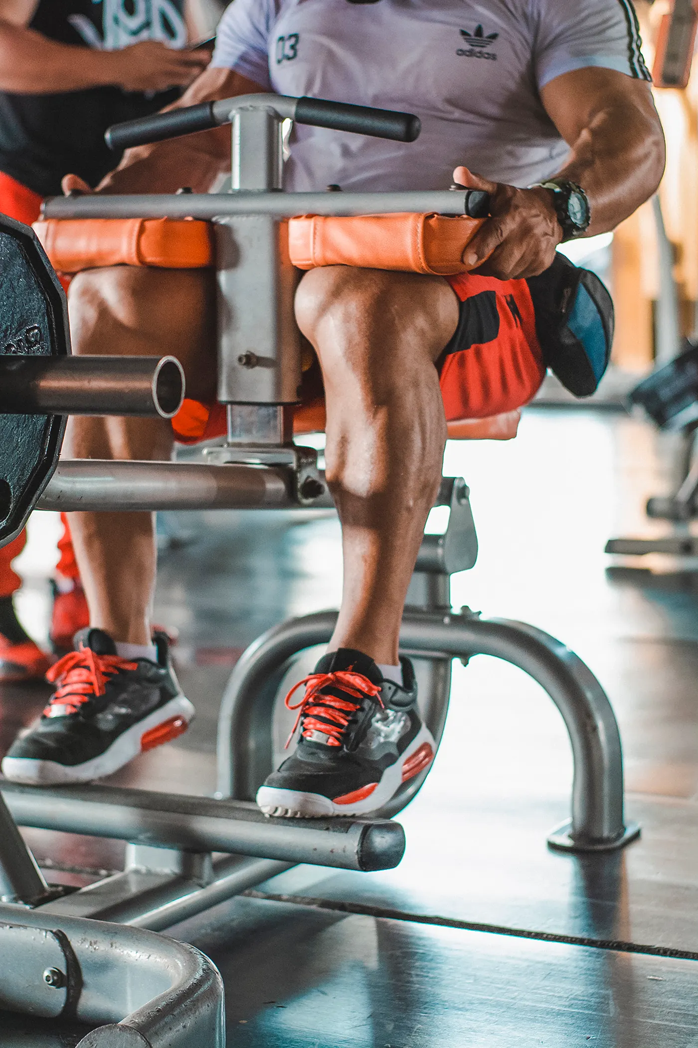 Athlete performing a lower-body machine exercise in a gym