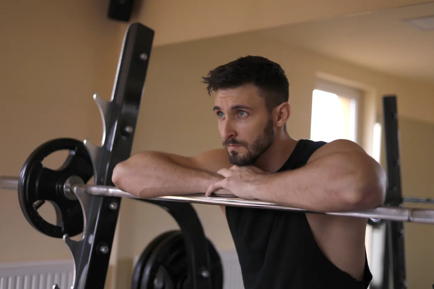 Strength athlete resting his arms on a barbell