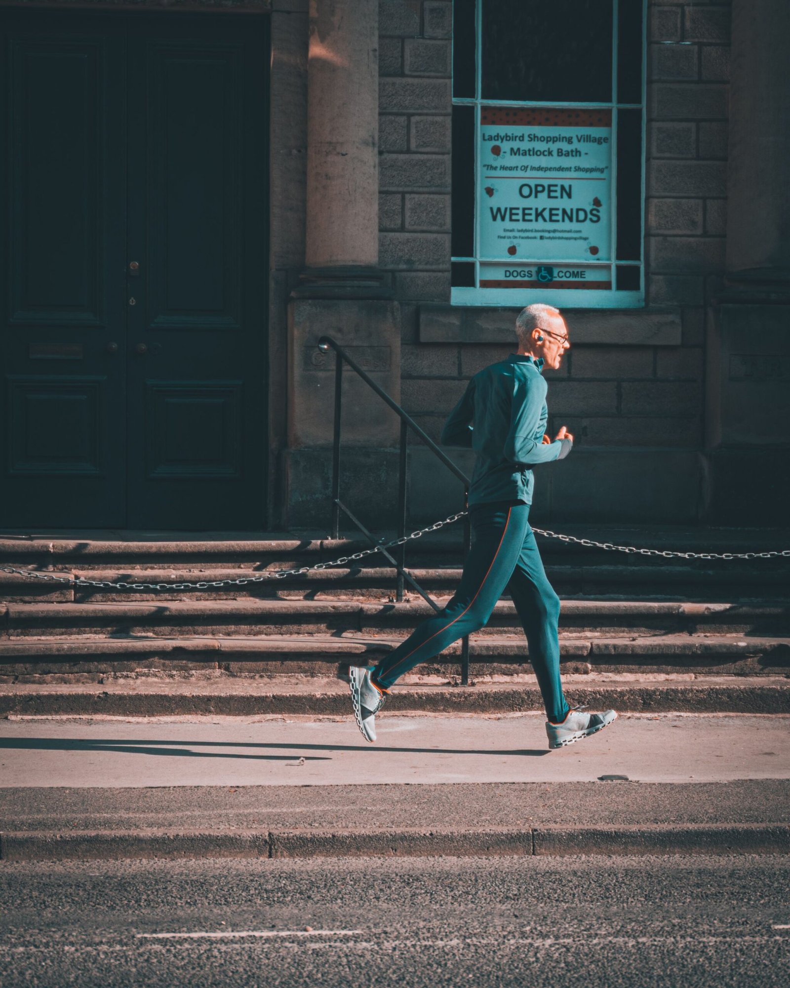 Older man jogging on a city pavement during a short outdoor activity break