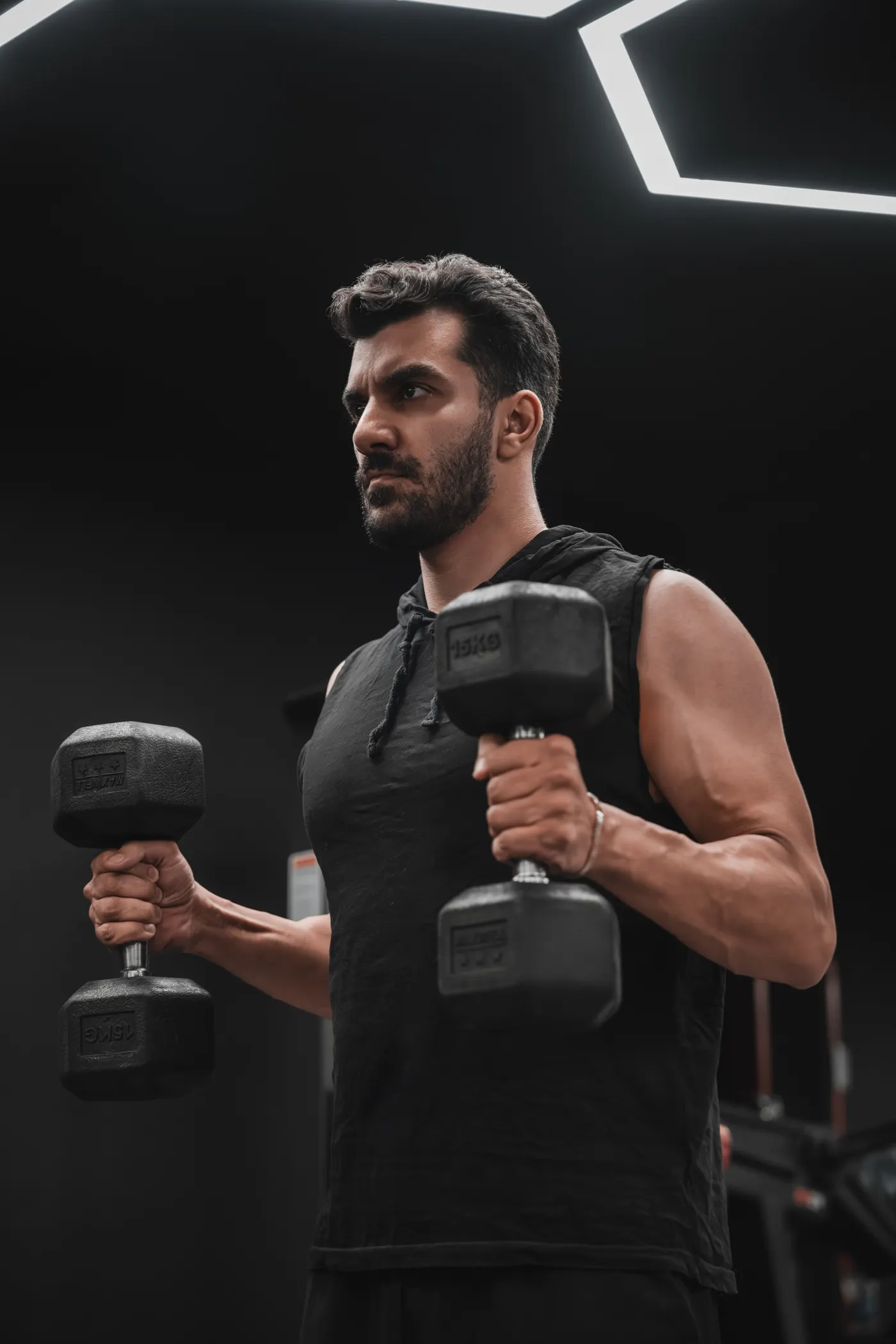 Athlete holding dumbbells during an arm workout in a gym