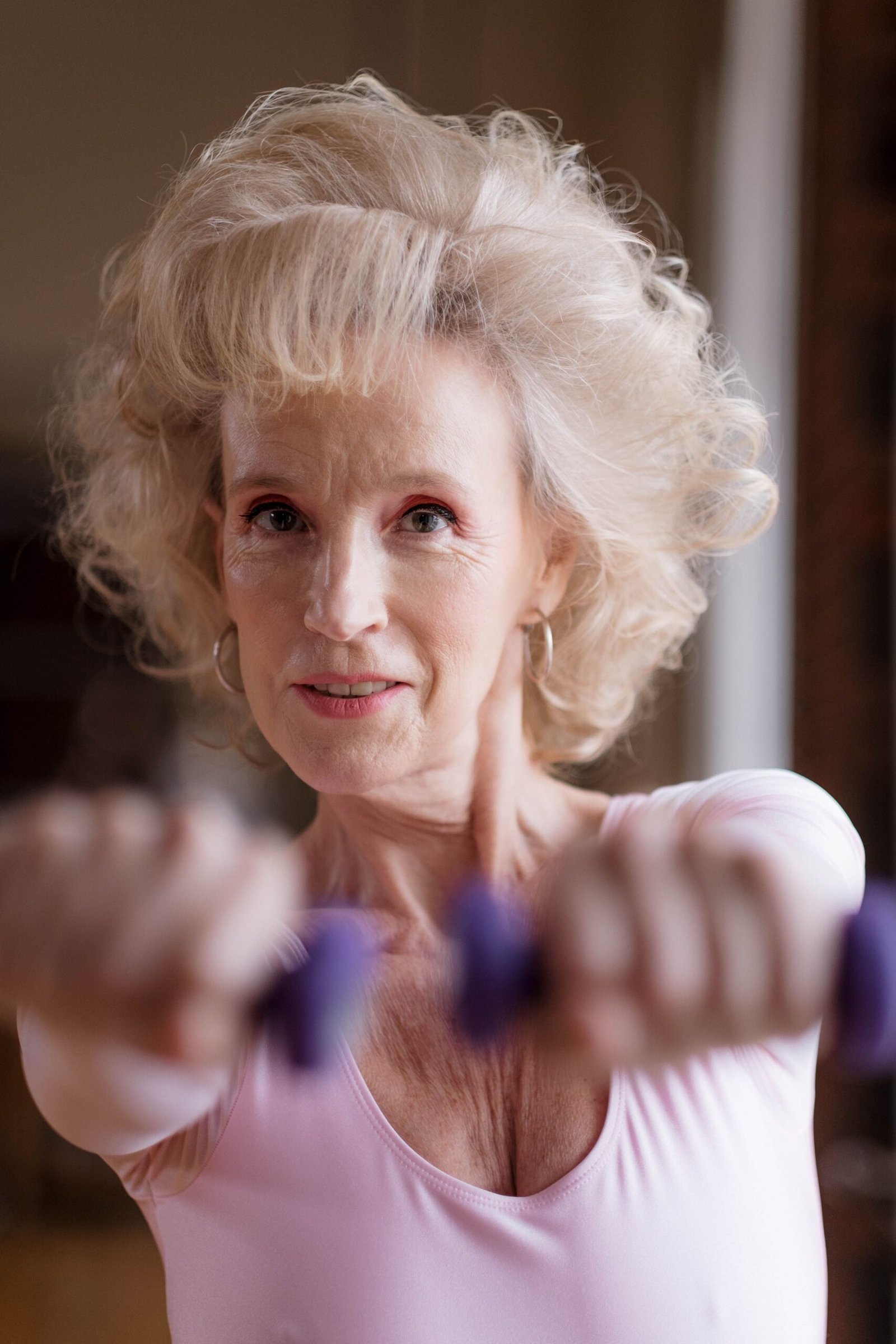 Older woman holding dumbbells during a home exercise routine