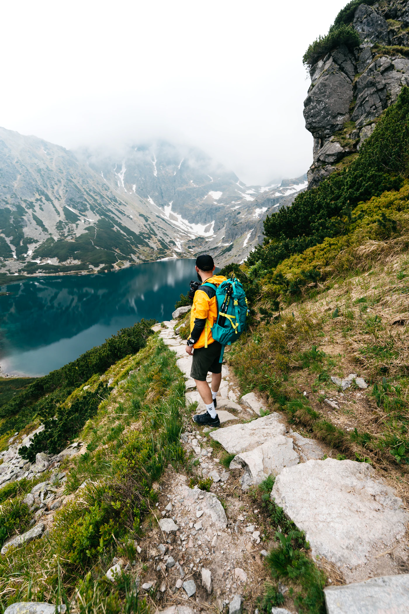Hiker carrying a backpack while climbing a mountain trail