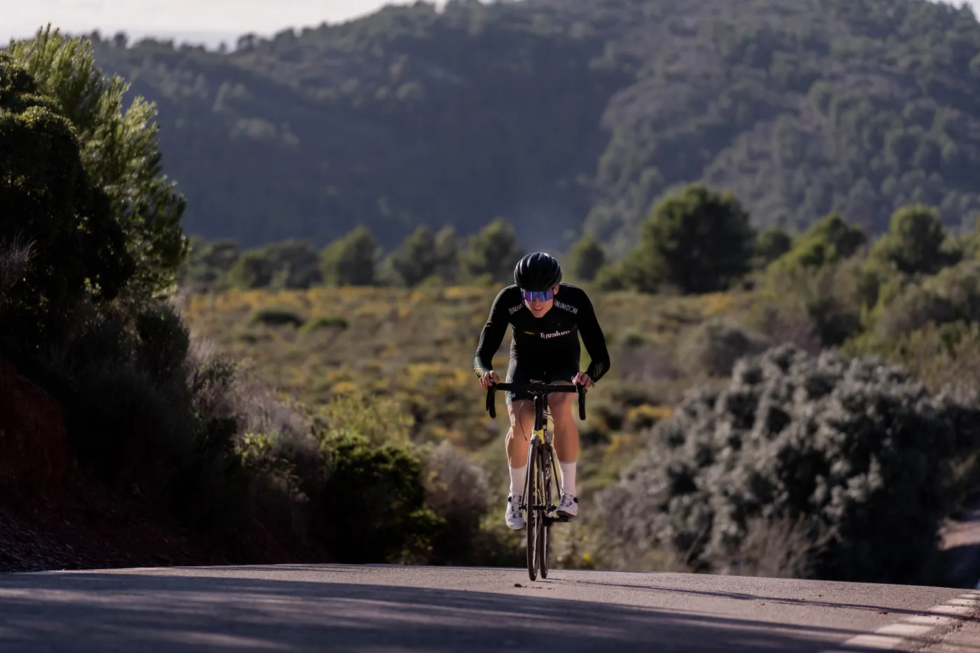 Road cyclist climbing a hill during endurance training