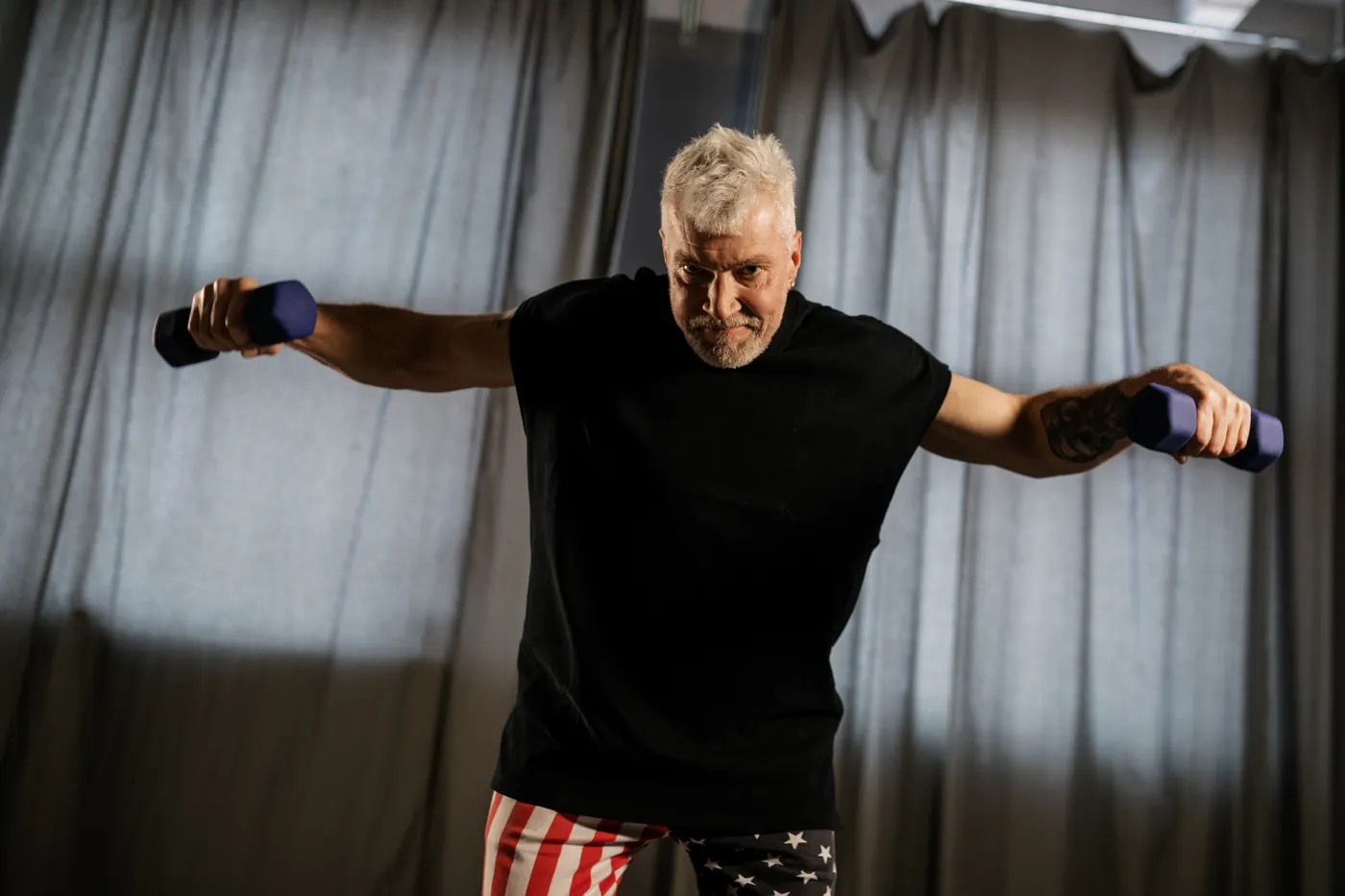 Older man lifting dumbbells during a strength workout