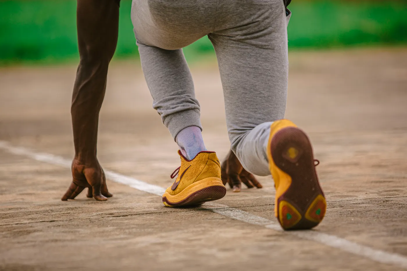 Athlete setting up for a sprint start on a running track