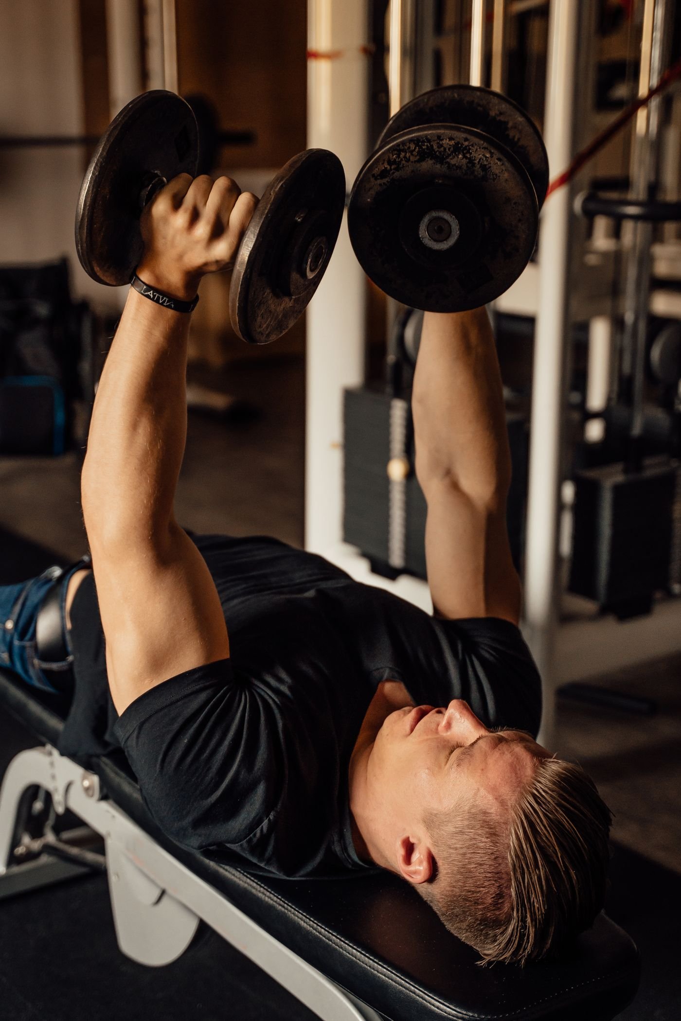 Man bench pressing dumbbells during resistance training