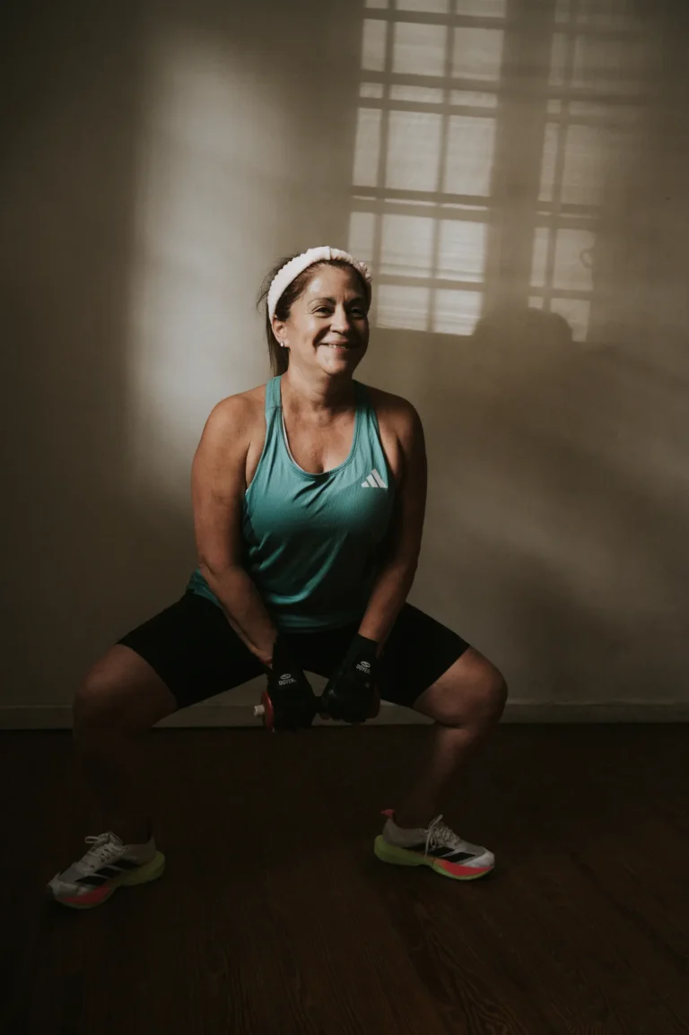 Middle-aged woman performing a weighted squat indoors