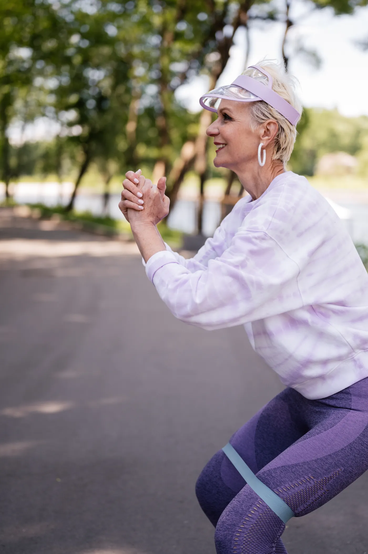 Older woman exercising outdoors with a resistance band