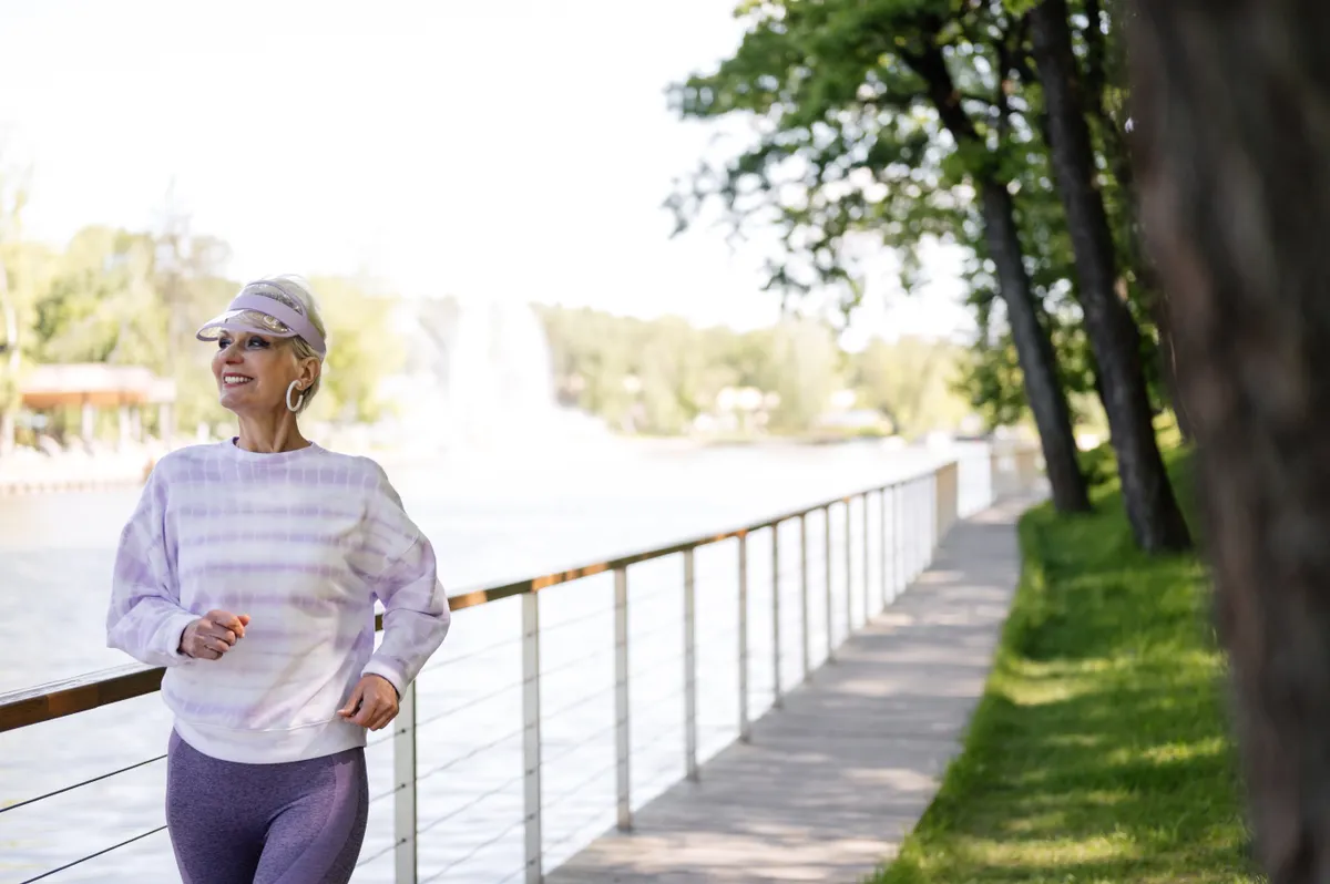 Older woman jogging on a scenic riverside path