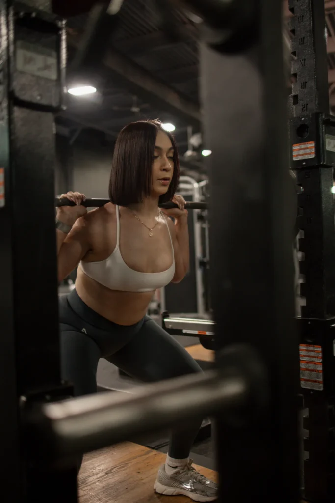 Woman performing a barbell squat in a gym