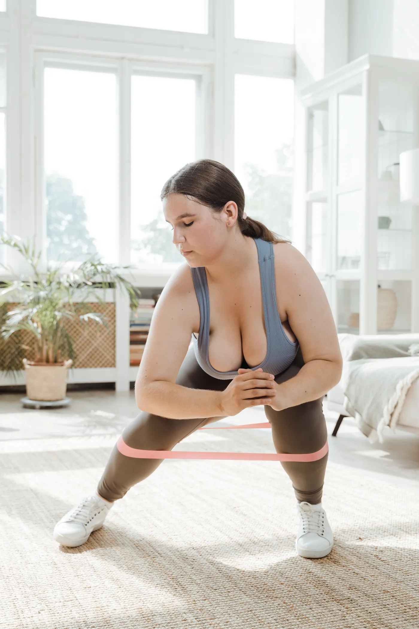 Woman performing a squat with a resistance band around her legs