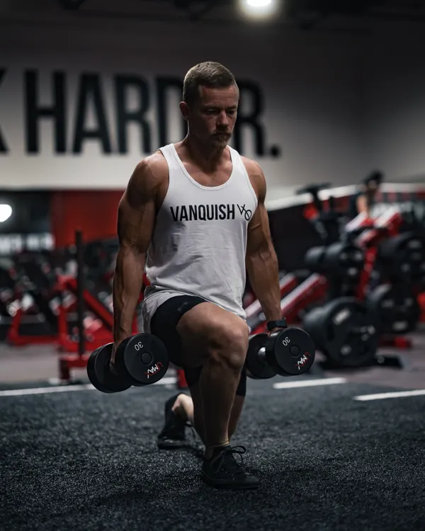 Lifter performing a dumbbell lunge for single-leg strength