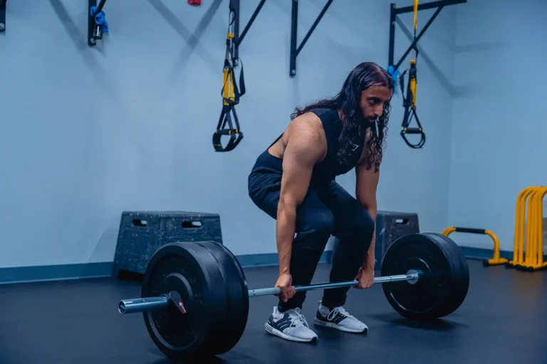 Athlete lifting a loaded straight barbell in a gym