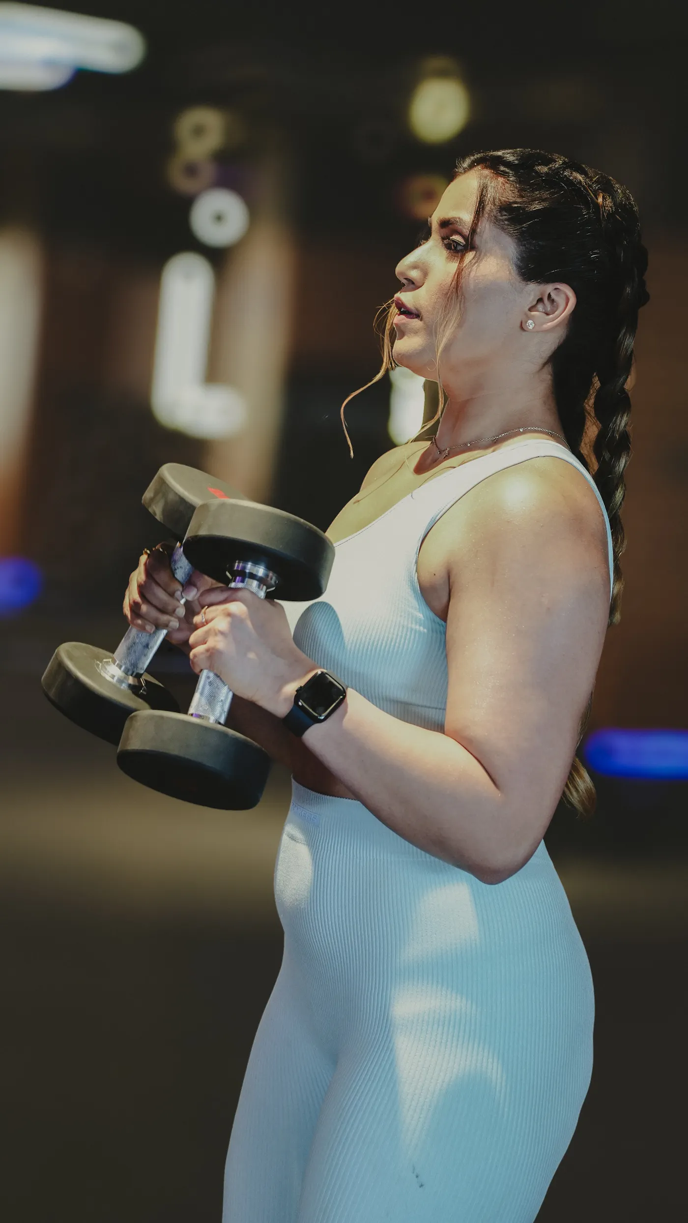 Woman lifting dumbbells in a gym during resistance exercise