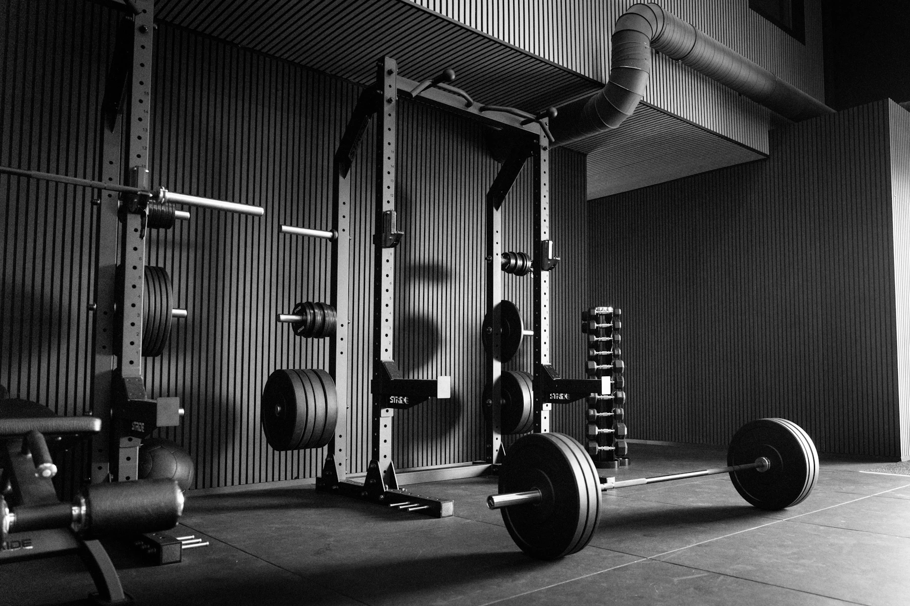 Modern strength gym with a power rack, barbells and weights