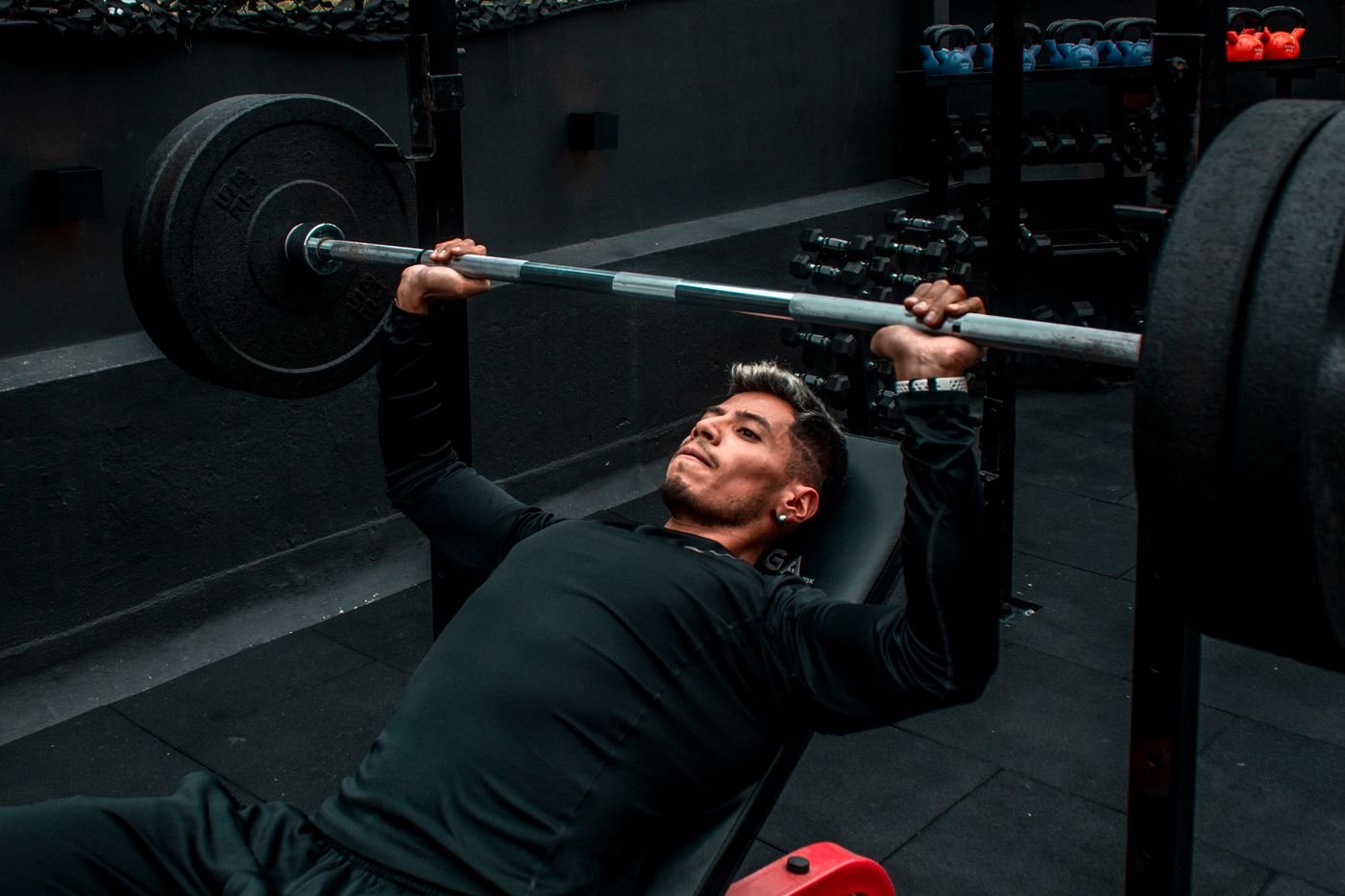 Athlete performing a barbell bench press during resistance training