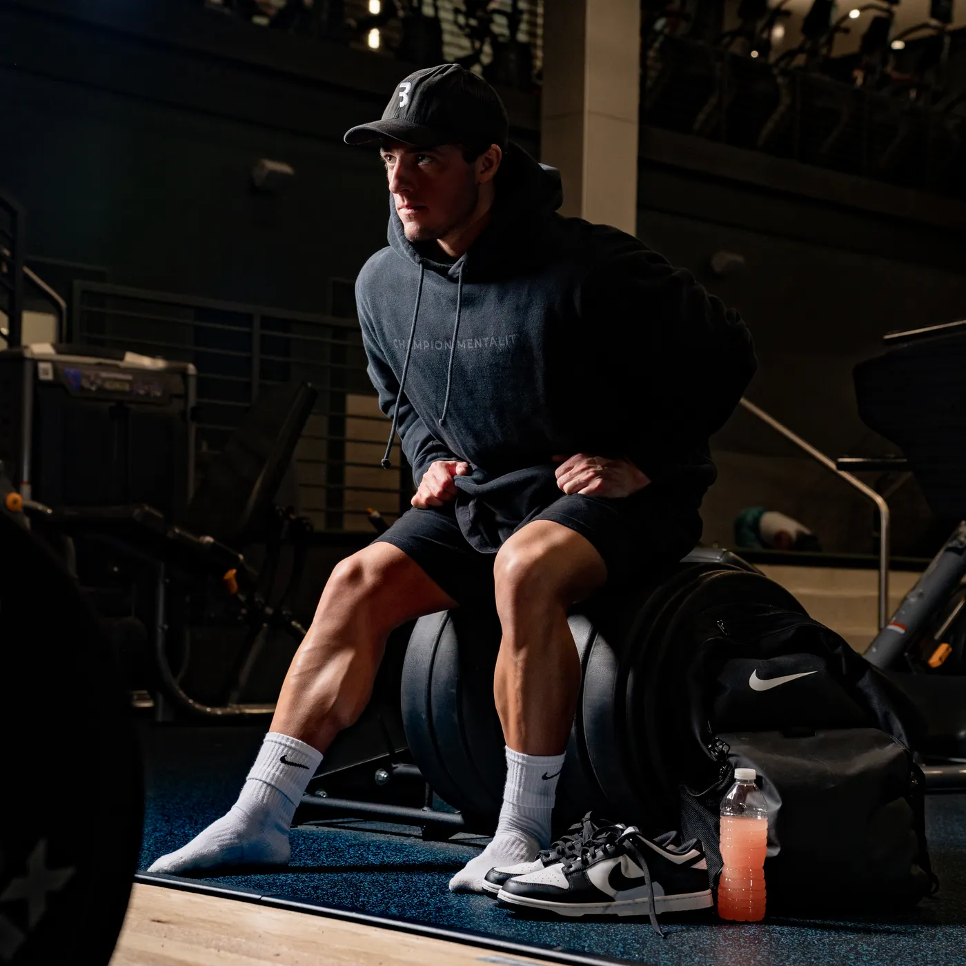 Athlete in a warm hoodie preparing to train in a gym
