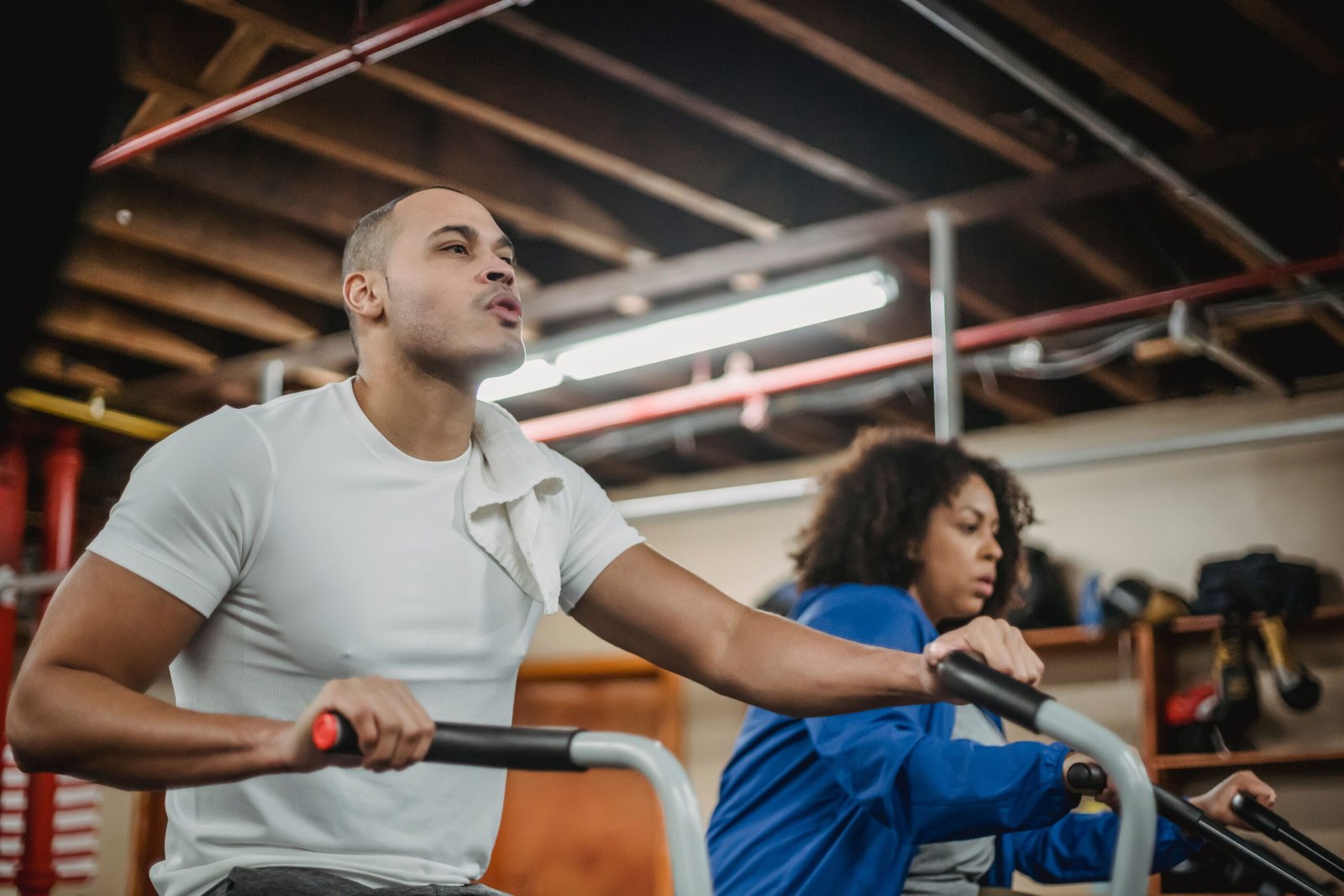 Two adults cycling on exercise bikes in a fitness class