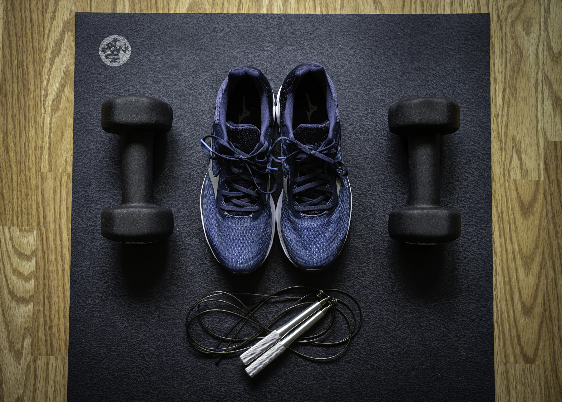 Compact home workout gear including dumbbells and training shoes