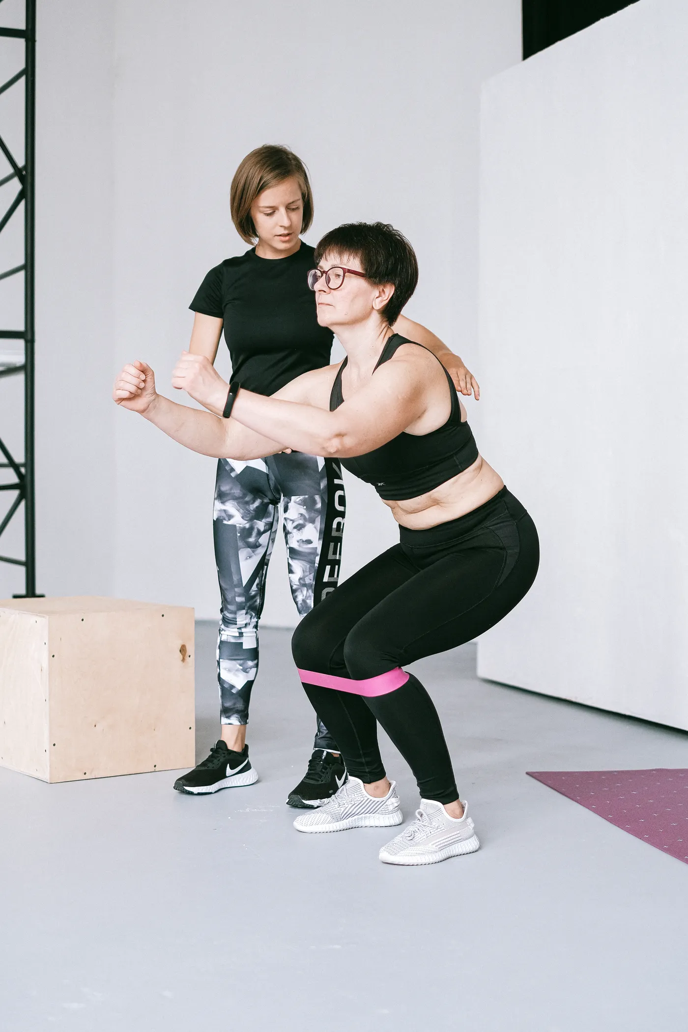 Personal trainer coaching resistance-band exercise and body positioning