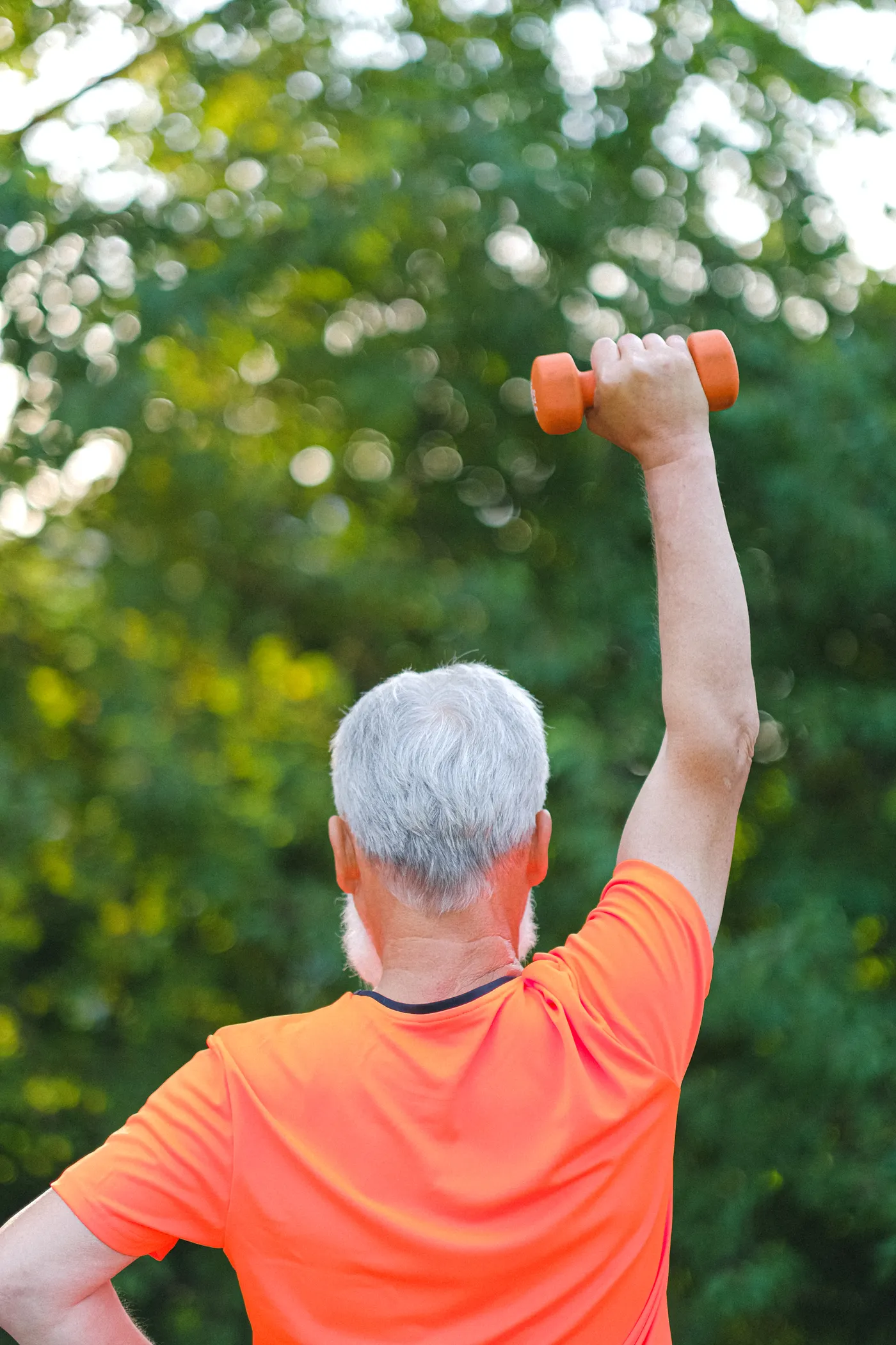 Senior man lifting a dumbbell outdoors