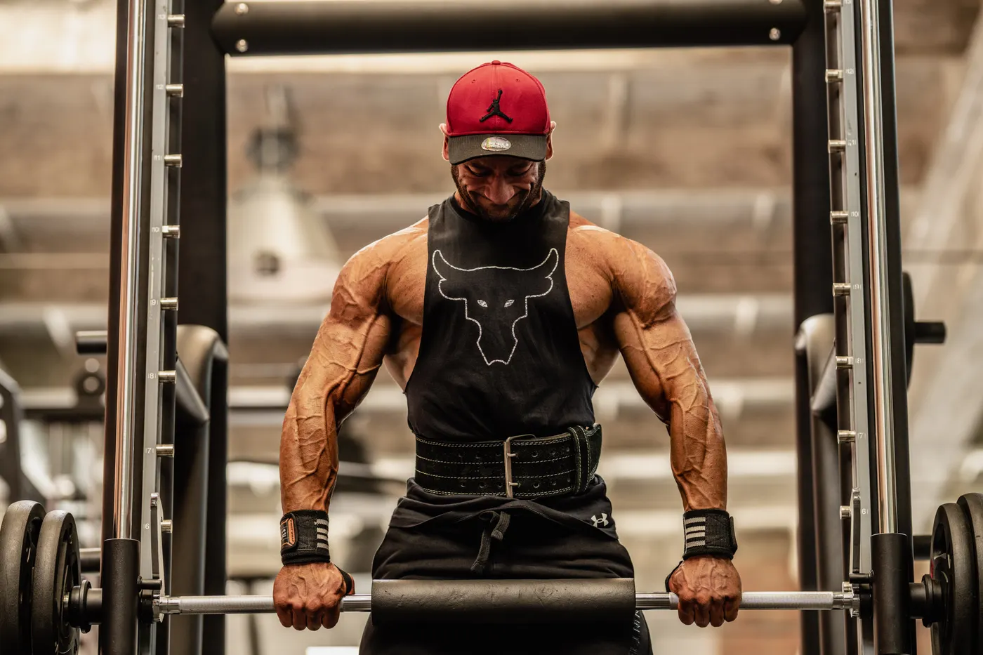 Muscular lifter training with a heavy barbell in a strength gym