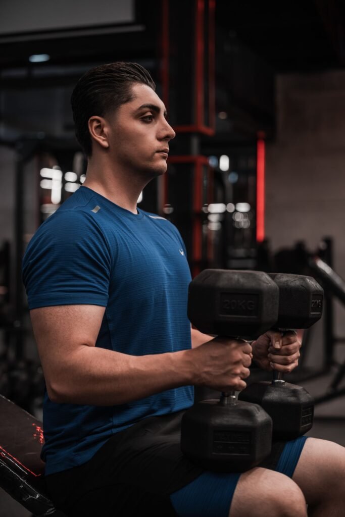 Focused lifter training with dumbbells in a modern gym