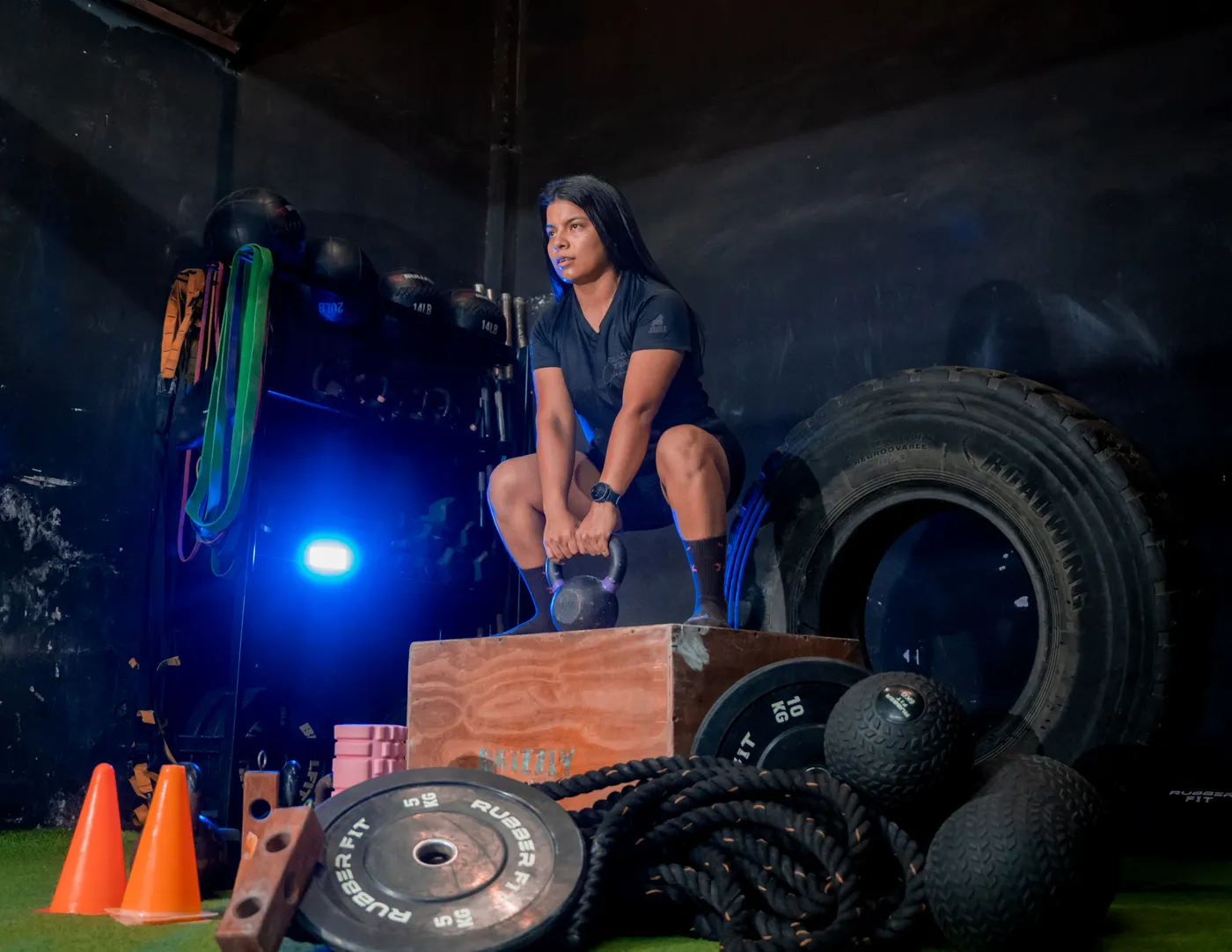 Woman holding a kettlebell while squatting in a gym