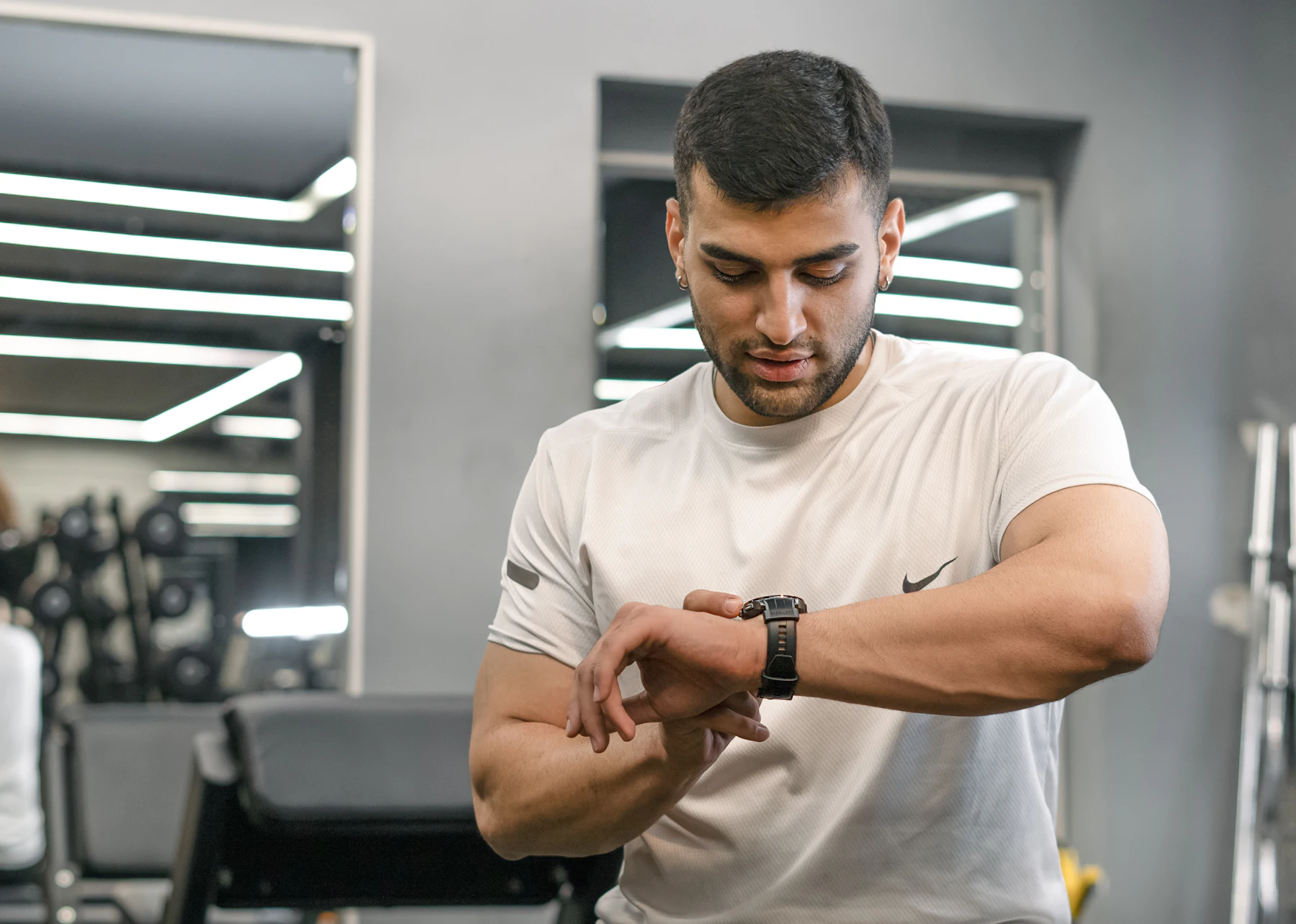 Gym athlete checking a smartwatch during a training session