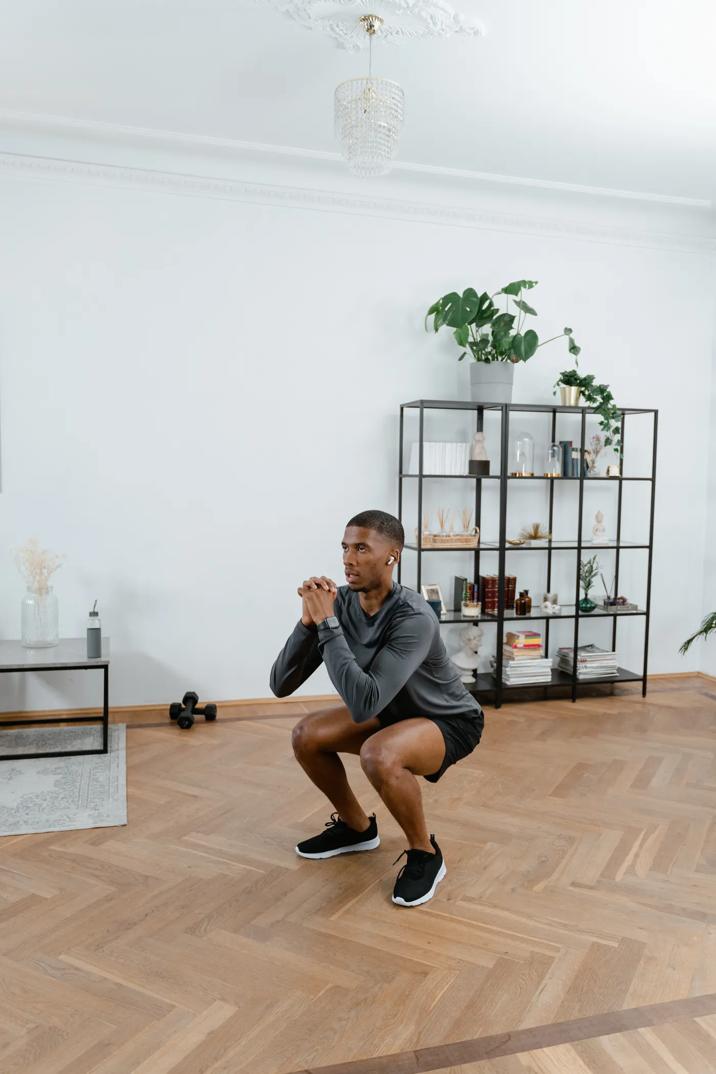 Man performing bodyweight squats indoors
