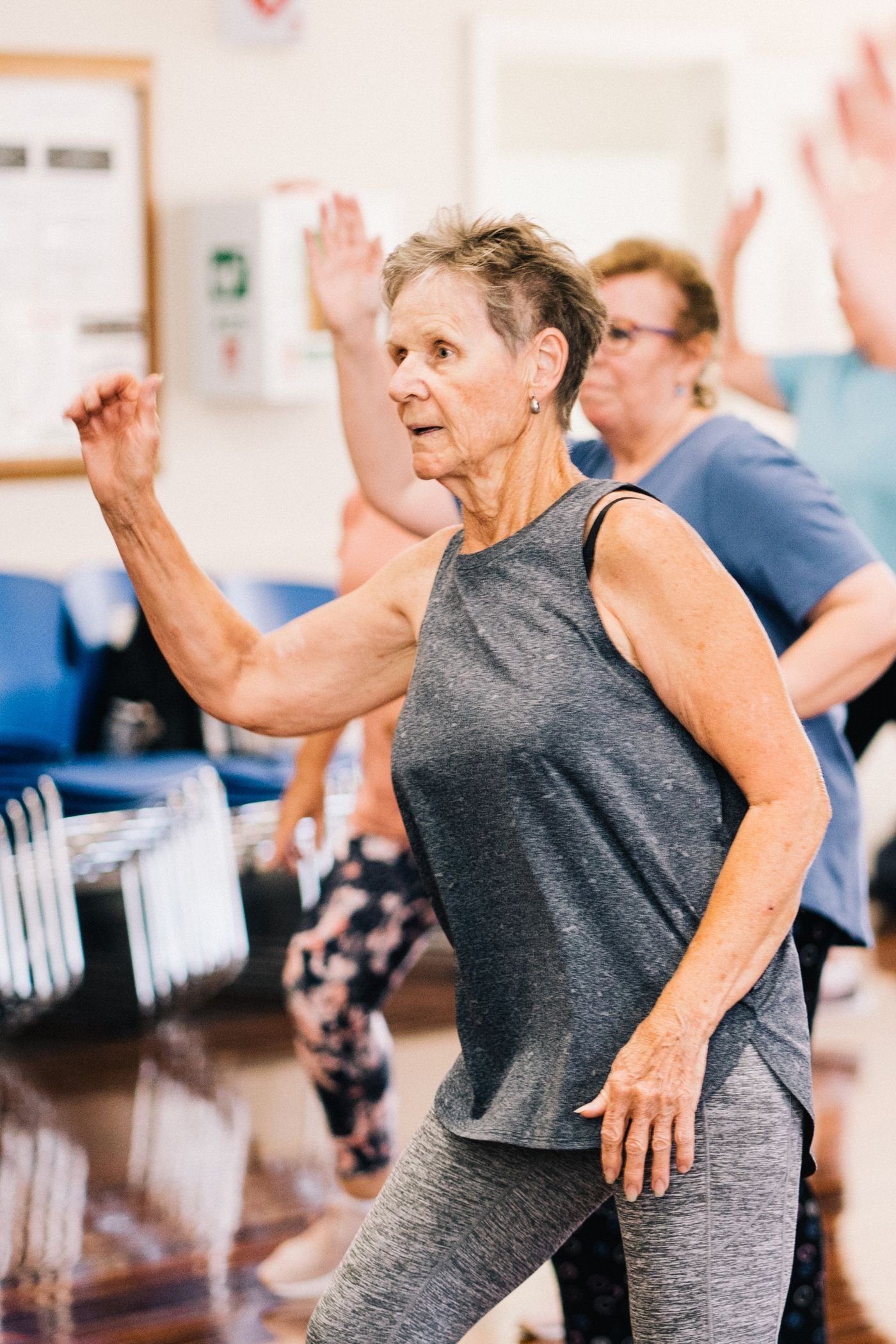 Older women moving in a lively group fitness class