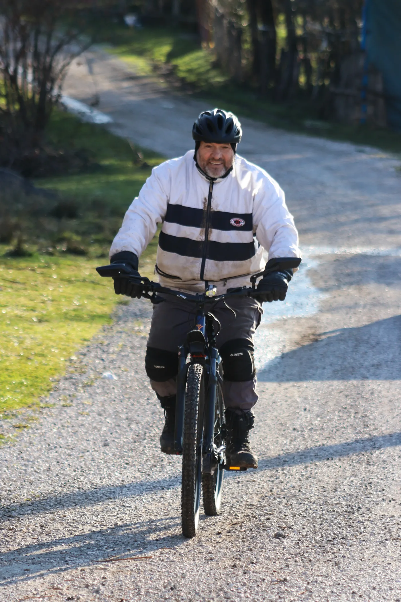 Cyclist riding along a sunny countryside gravel path