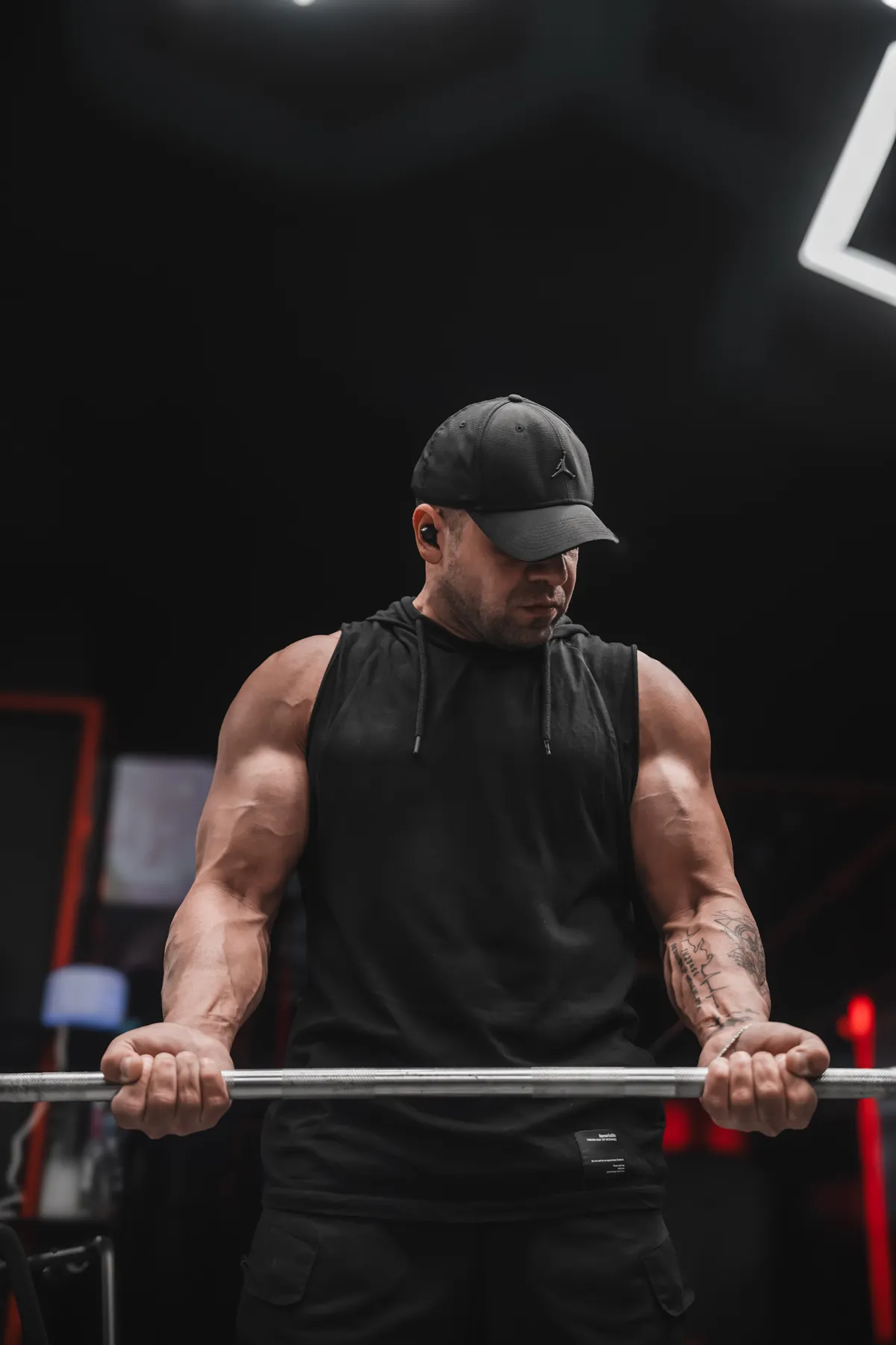 Focused lifter performing a barbell curl in a gym